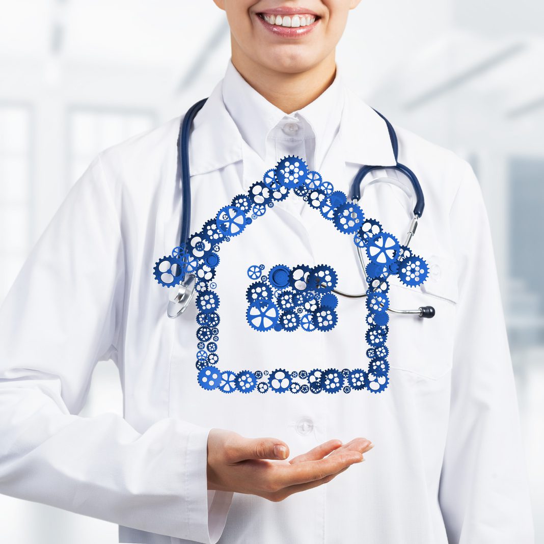 Hand of woman doctor showing house or home gear sign in palm